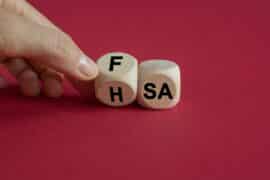 FSA or HSA symbol. Turned a cube and changed the word FSA - Flexible Spending Account to HSA - Health Savings Account. Beautiful red background. Business and FSA or HSA concept.