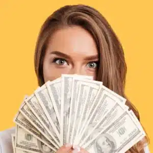 Woman holding cash covering her mouth