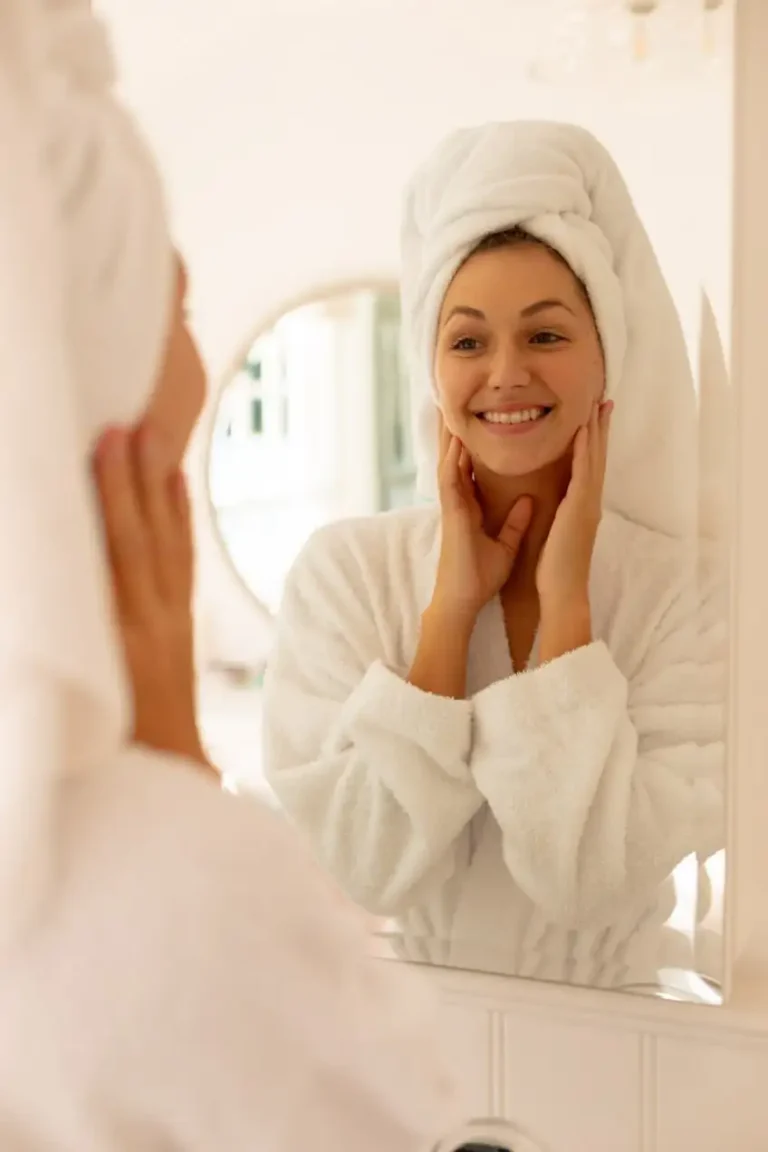 Woman looking at her skin in a mirror during her skincare routine