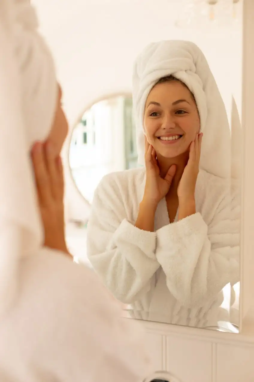 Woman looking at her skin in a mirror during her skincare routine