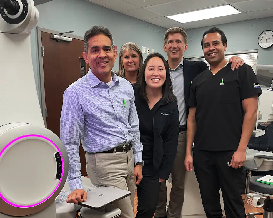 Clear Choice doctors and staff smiling together beside vision correction equipment in our office