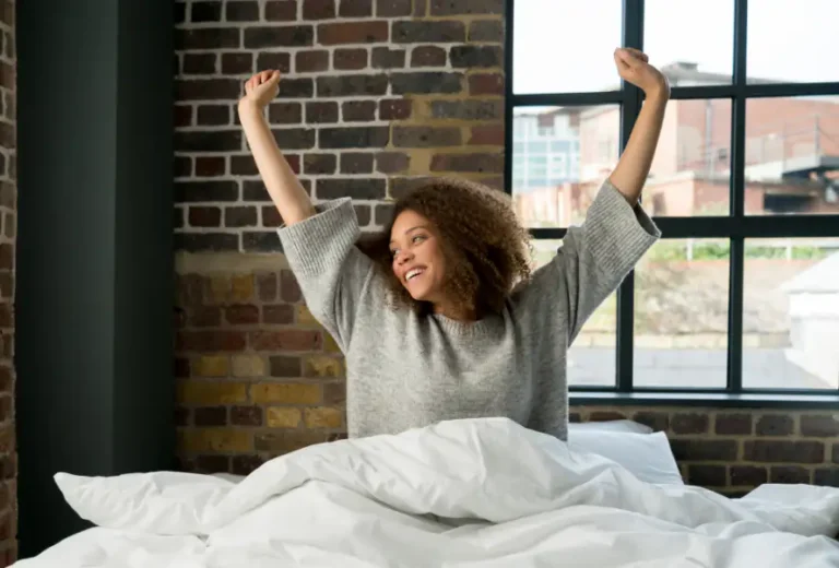 Woman waking up and stretching in bed without glasses
