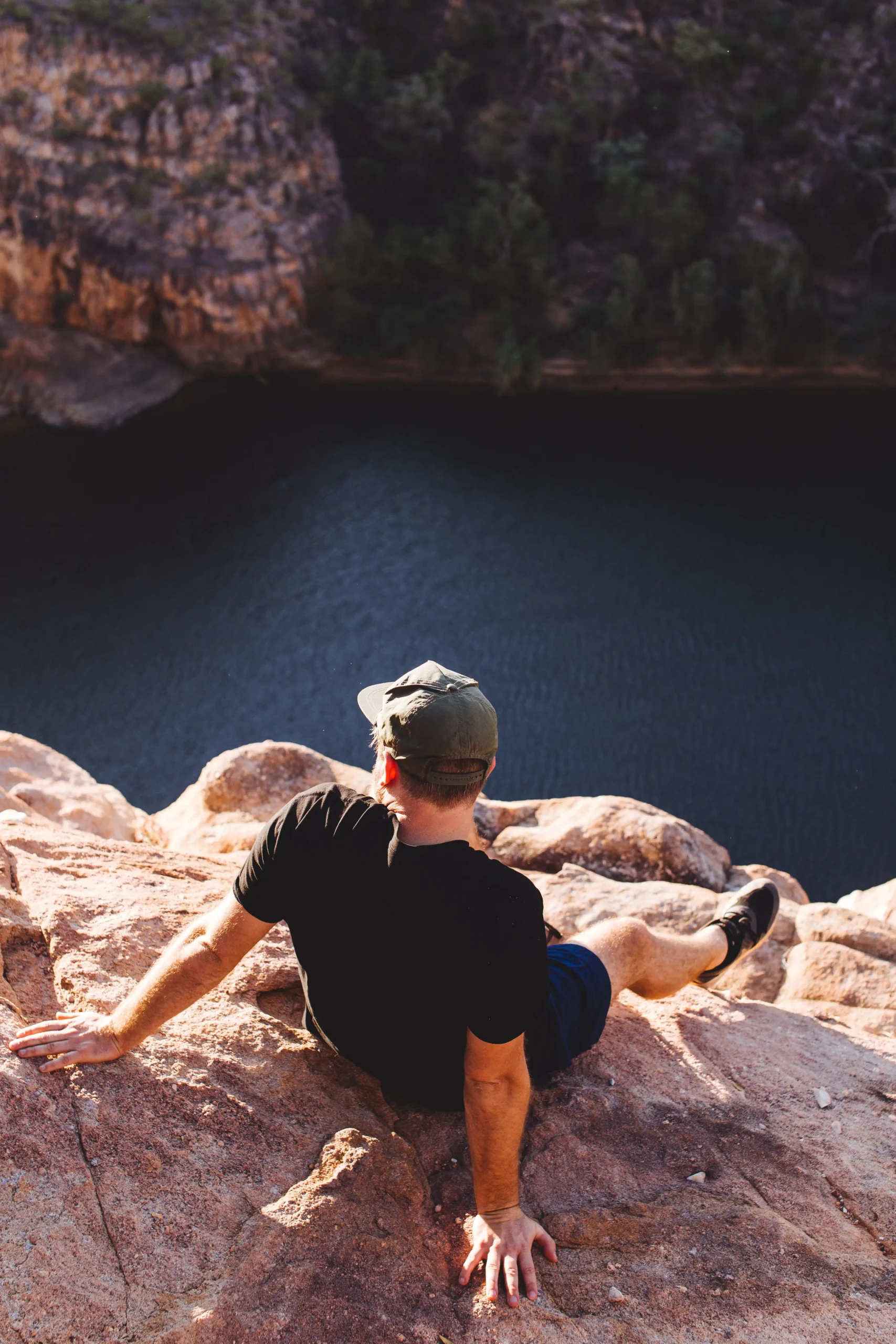 Hiker sitting on a rocky overlook above a canyon