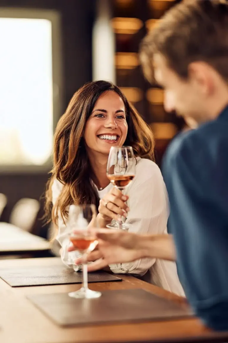Woman smiling and talking with a companion at a restaurant